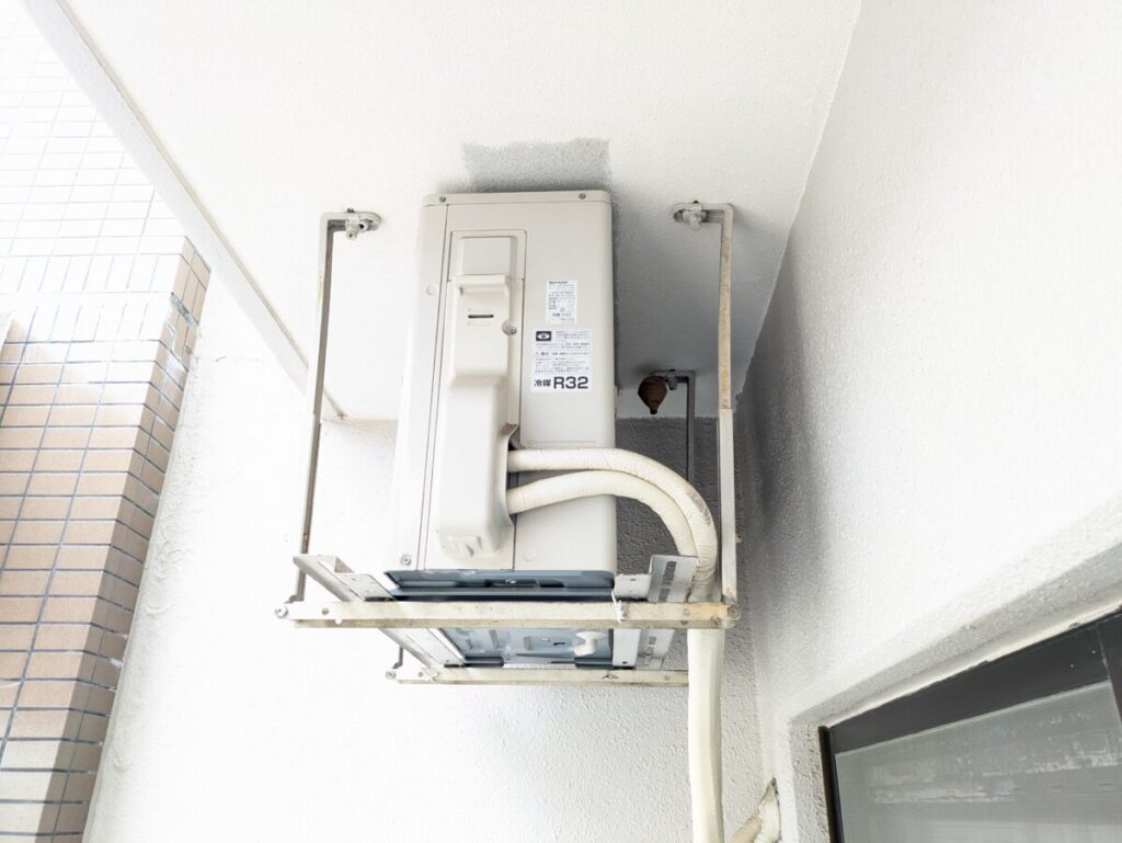 名古屋市千種区のマンション9階ベランダにて、吊り下げ式室外機の裏の死角に作られたコガタスズメバチの初期の巣(壺型・トックリ型)。